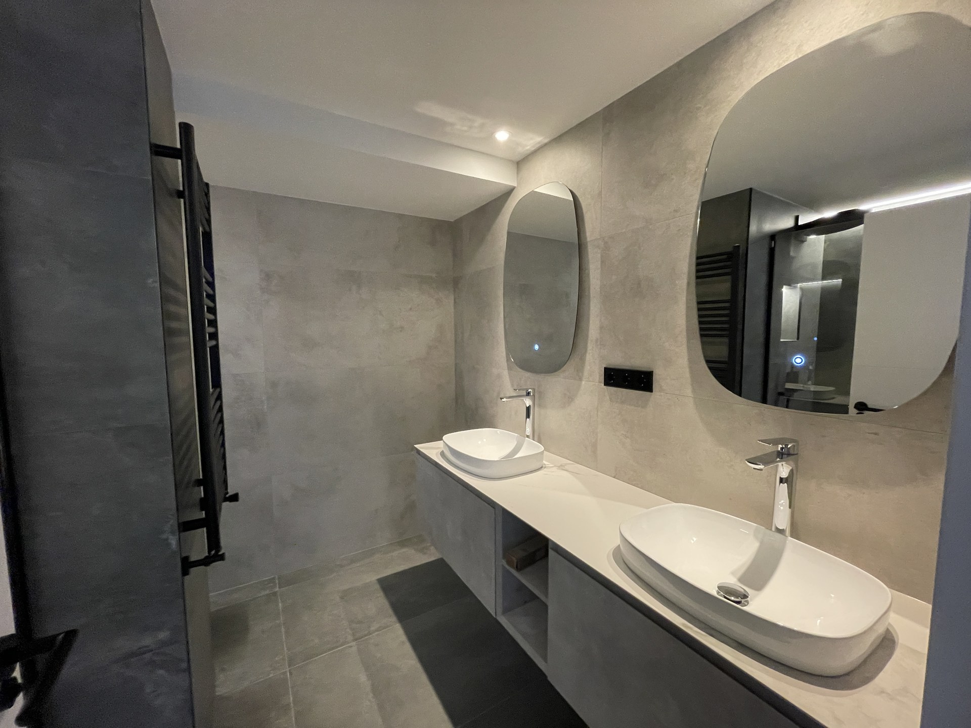 Baño con doble lavabo e iluminación integrada en Conde de Casal